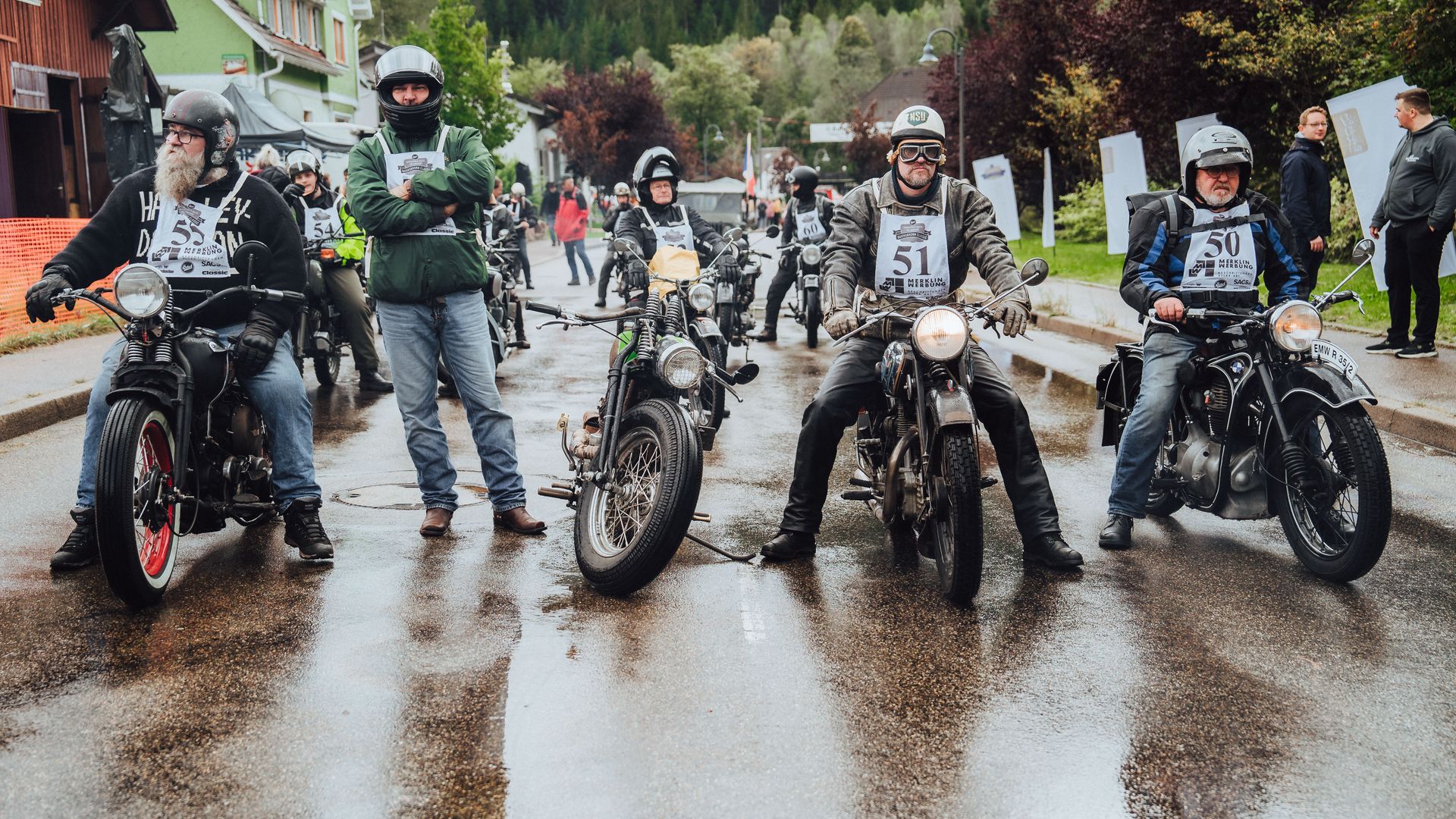 Mehrere Teilnehmer der Baiersbronn Classic warten auf ihren Oldtimer Motorrädern auf den Start des Bergrennens