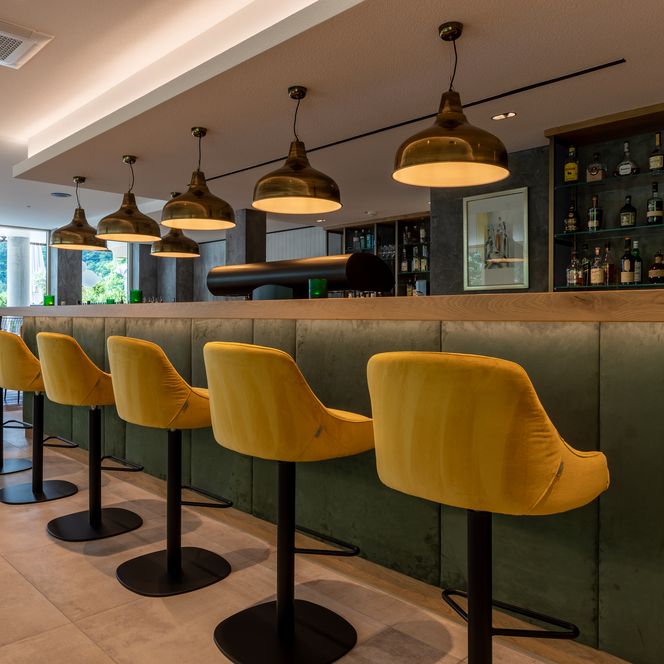 Gelbe Barstühle an der Theke der RheinHOLZ Café-Bar des Genusshotels Sackmann in Schwarzenberg