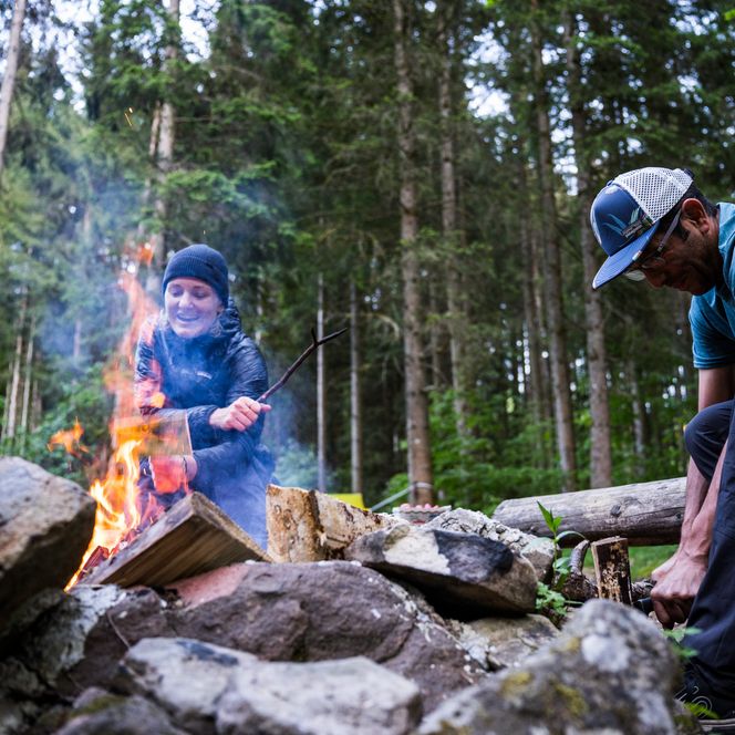Personen zünden ein Lagerfeuer im Trekking-Camp in Baiersbronn an