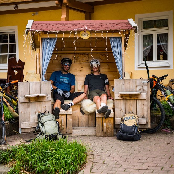 Zwei Biker entspannen in der kleinen Holzhütte vor dem Wellnesshotel Tanne in Tonbach