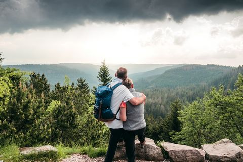 Ein Paar genießt die Aussicht am Wildseeblick und umarmt sich.
