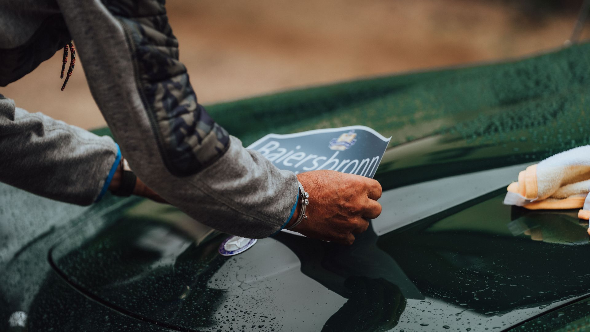 Ein Teilnehmer der Baiersbronn Classic beklebt seinen Oldtimer mit seiner Startnummer