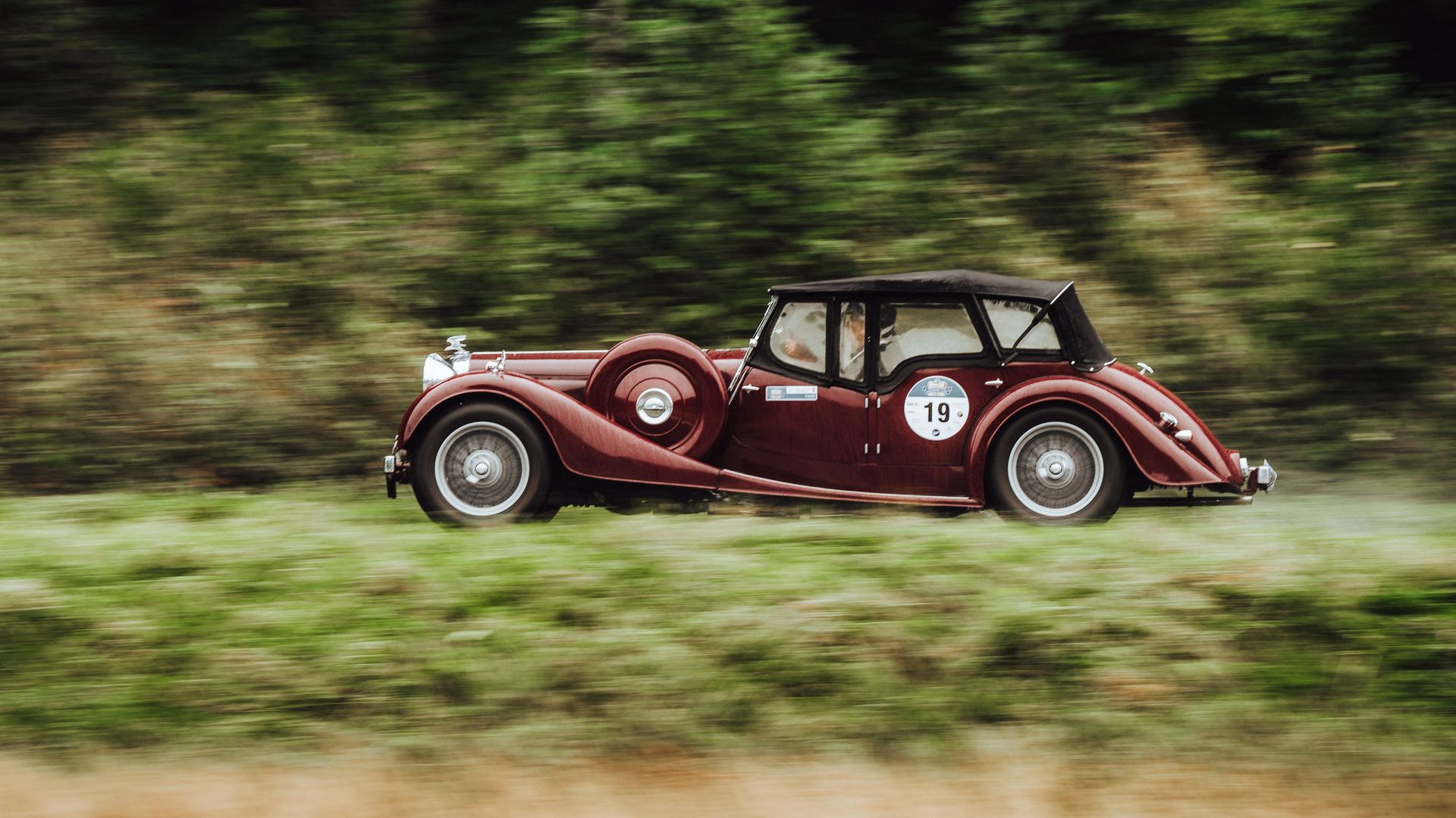 Ein dunkelroter Oldtimer fährt bei der Baiersbronn Classic