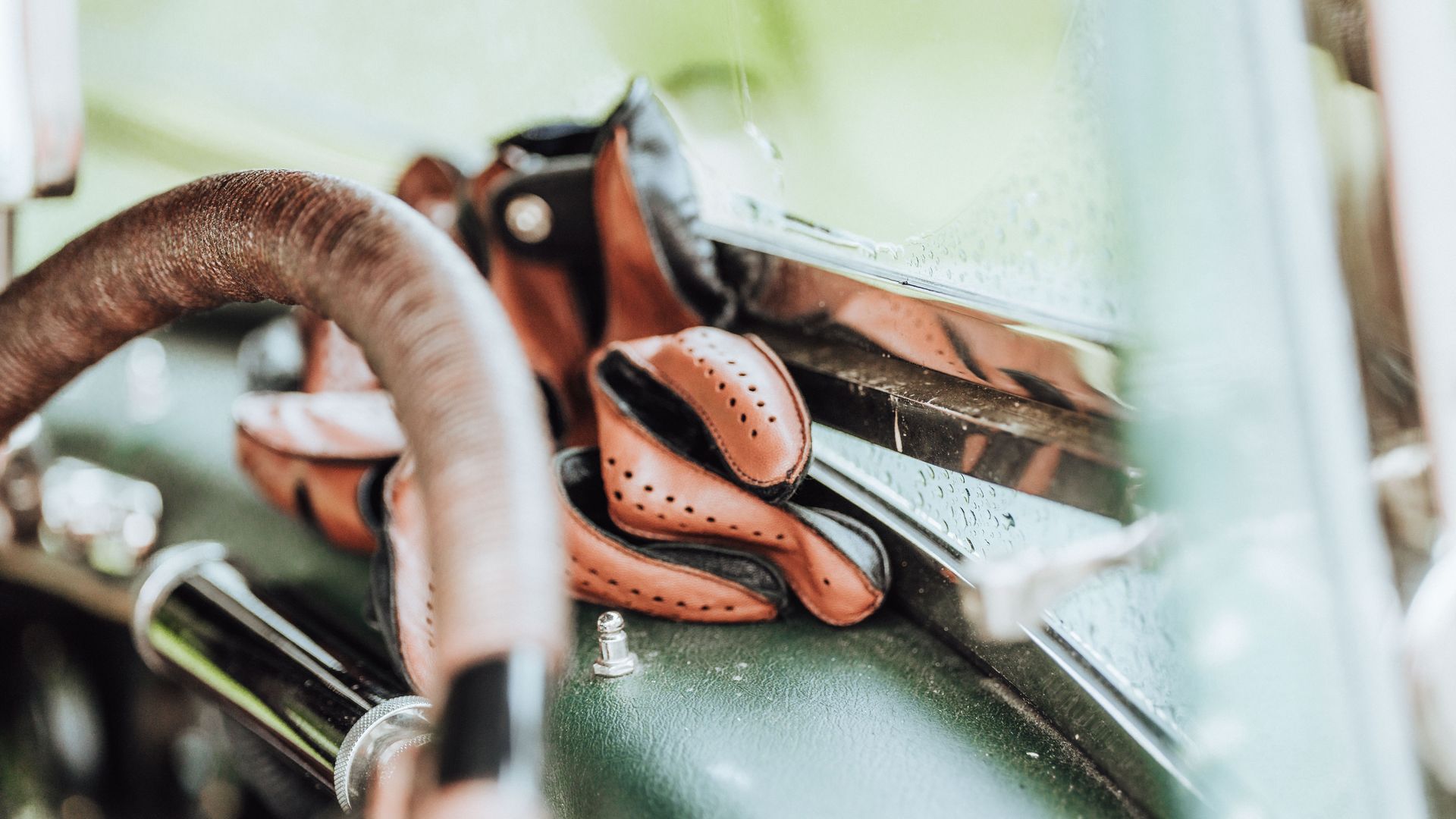 braune Lederhandschuhe liegen auf der Armatur eines Oldtimers