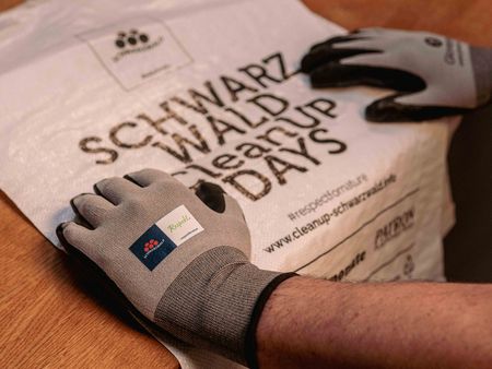 Zwei Hände mit Handschuhe mit einem Müllsack der CleanUP Days