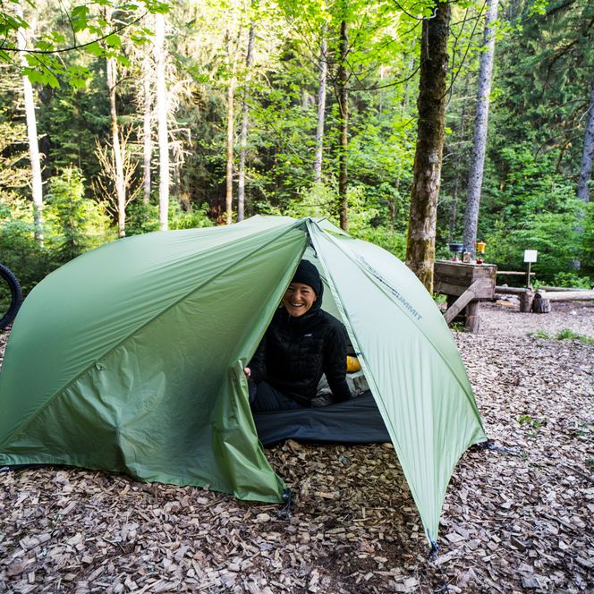 Eine Person schaut aus ihrem Zelt im Trekking-Camp in Baiersbronn