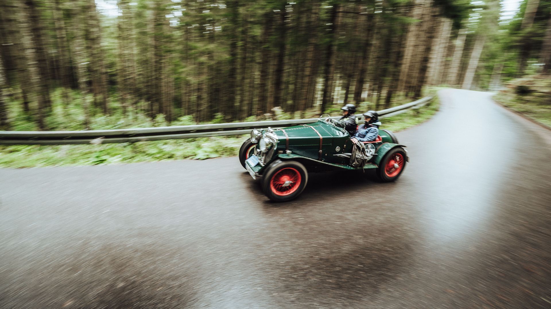 EIn grünes Oldtimer-Cabrio fährt um eine Kurve bei der Baiersbronn Classic