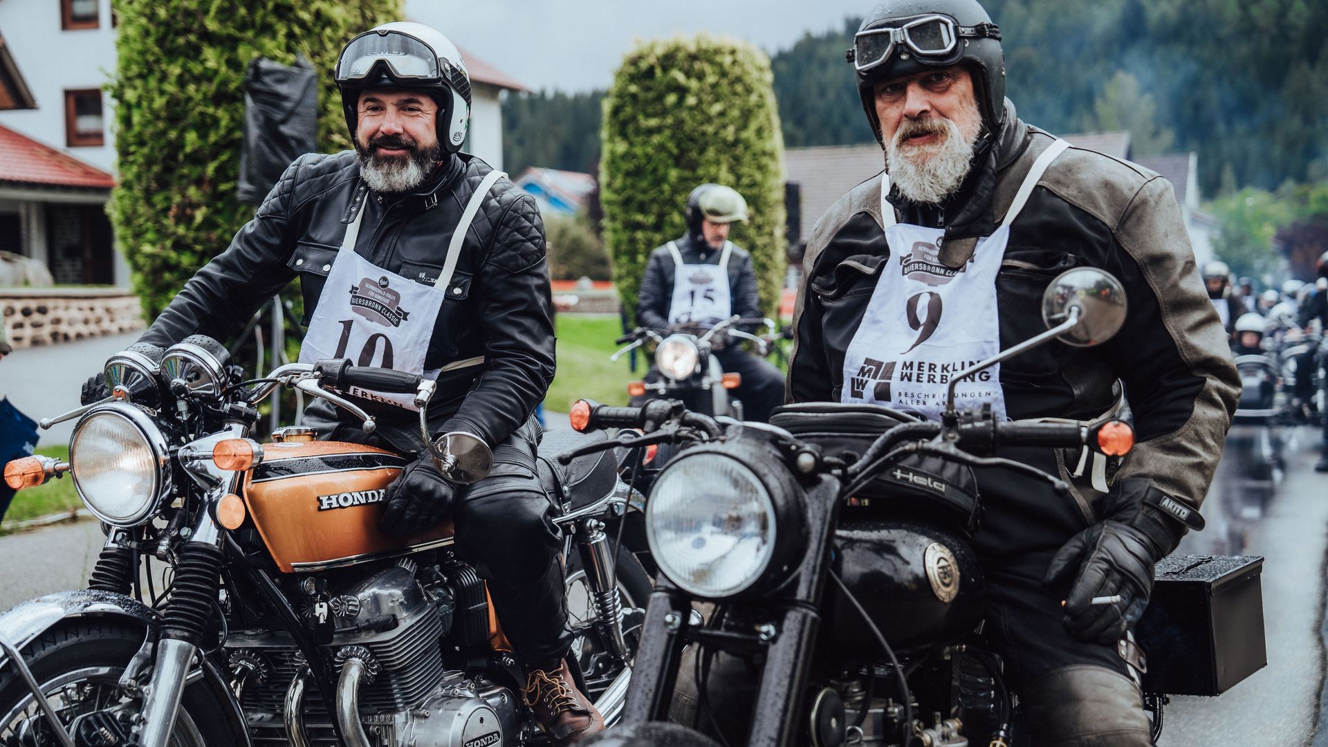 Mehrere Teilnehmer der Baiersbronn Classic warten auf ihren Oldtimer Motorrädern auf den Start des Bergrennens
