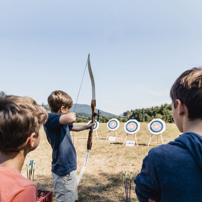 Drei Kinder beim Bogenschießen in Baiersbronn.