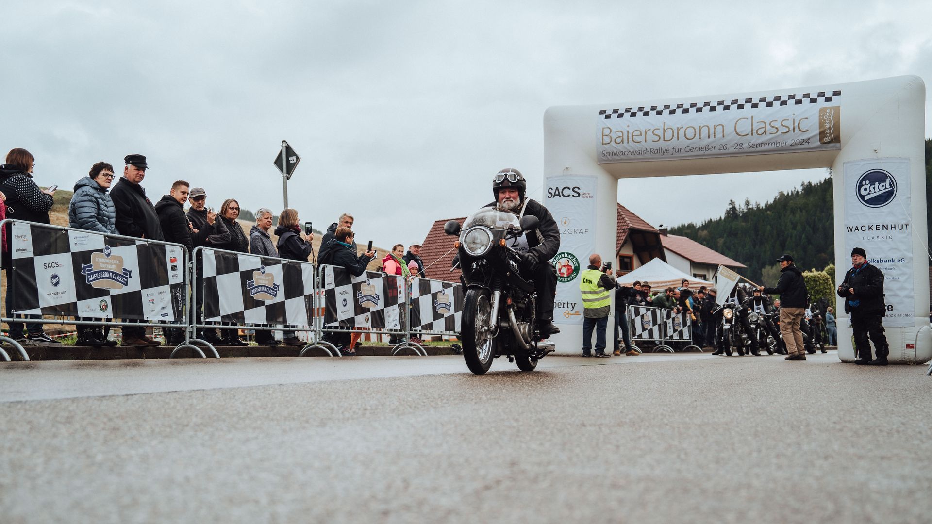 Ein Teilnehmer der Baiersbronn Classic fährt auf seinem Oldtimer Motorrad durch den Startbogen