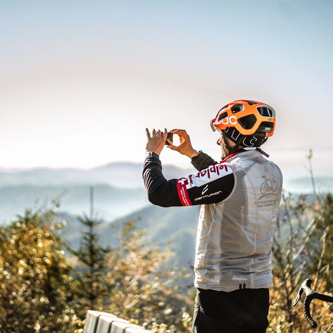 EIn Biker fotografiert unterwegs auf einer Graveltour die Landschaft im Nationalpark Schwarzwald