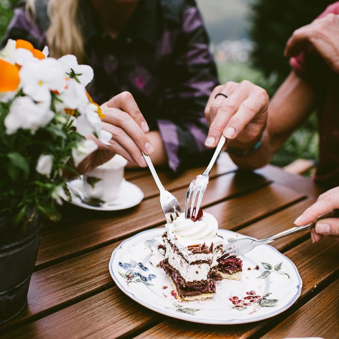 Drei Personen essen ein Stück einer Schwarzwälder Kirschtorte in Baiersbronn