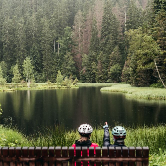Mountainbikefahrer machen Pause auf einer Bank am Buhlbachsee