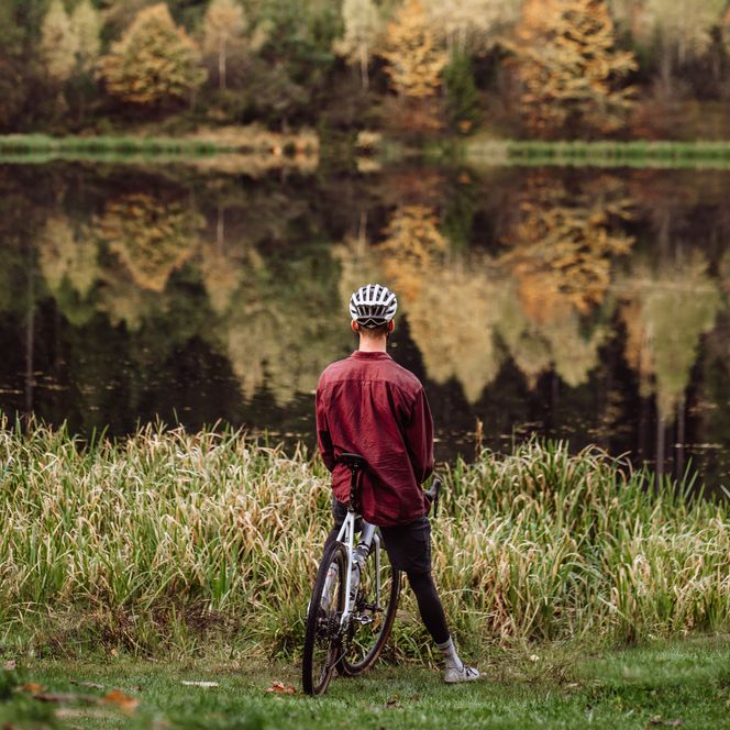 Eine Person steht mit dem Gravelbike am Sankenbachsee in Baiersbronn