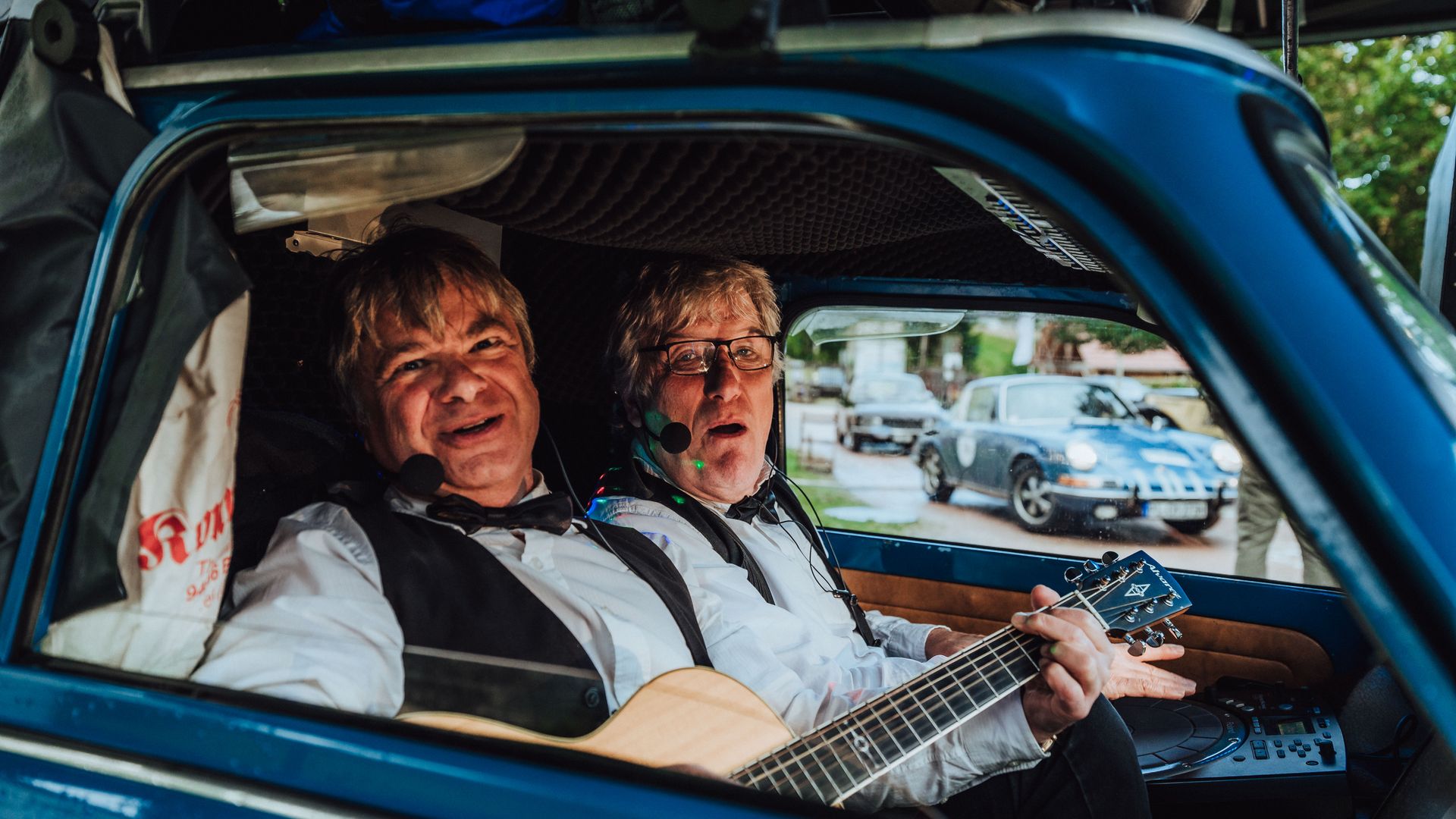 Zwei Entertainer singen Lieder in der Lebenden Musikbox mit einer Gitarre