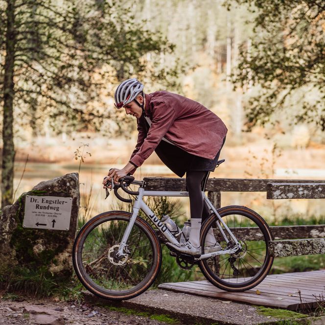 Eine Person fährt mit dem Gravelbike über eine Holzbrücke in Baiersbronn