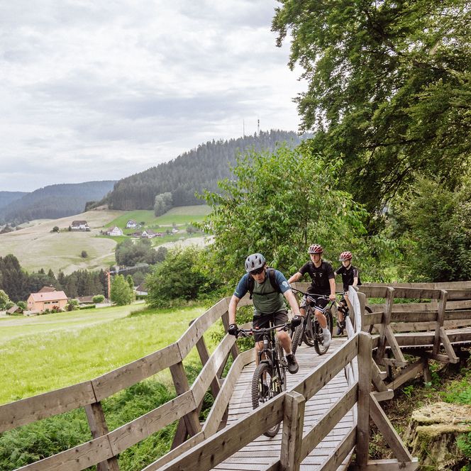 Biker fahren über eine Fahrtechnik-Station der Kids Tonbach Tour